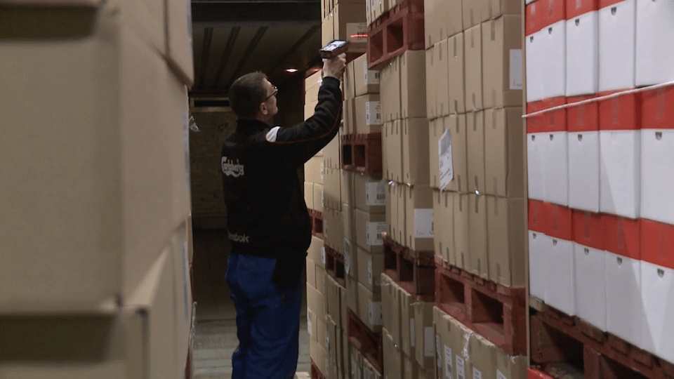 Warehouse worker scanning goods in a distribution center with a scanner