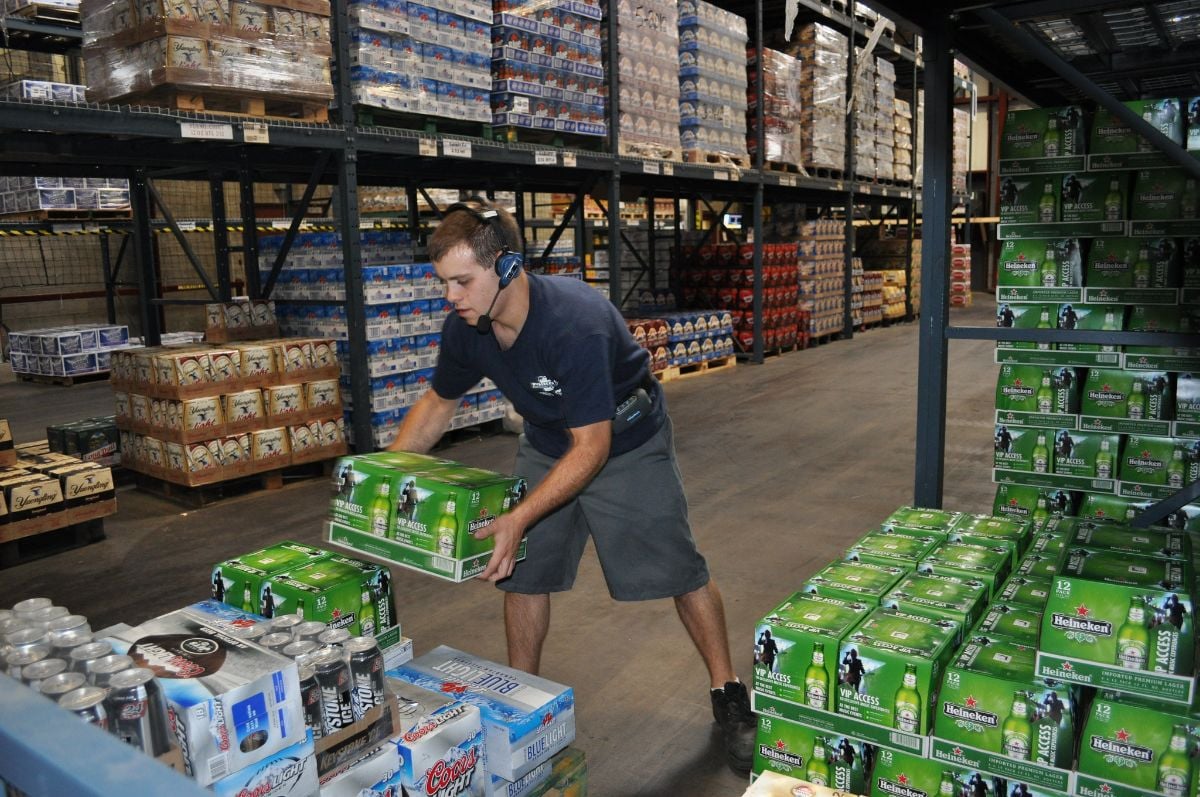 Warehouse worker voice picking beer in a distribution center
