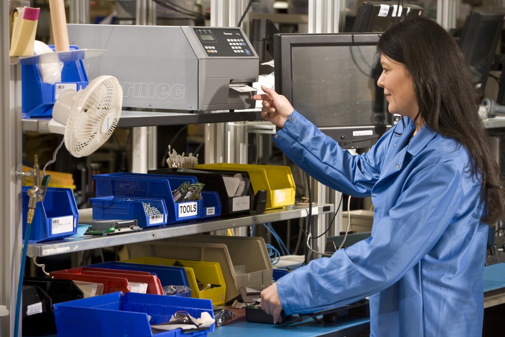 Warehouse worker taking a barcode label from an industrial Honeywell printer