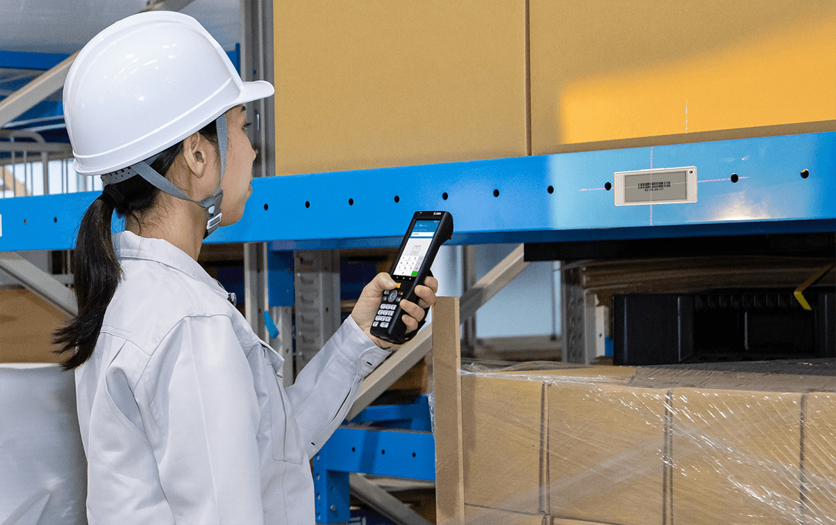 Warehouse worker scanning an electronic shelf label with a barcode scanner